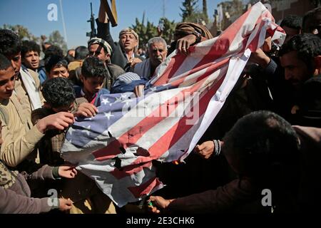 Sanaa, Yemen. 18 gennaio 2021. I sostenitori di Houthi bruciano una bandiera statunitense durante una protesta davanti all'ambasciata statunitense a Sanaa contro gli Stati Uniti per la decisione di designare il movimento dei ribelli Houthi come organizzazione terroristica straniera. Credit: Hani al-ANSI/dpa/Alamy Live News Foto Stock