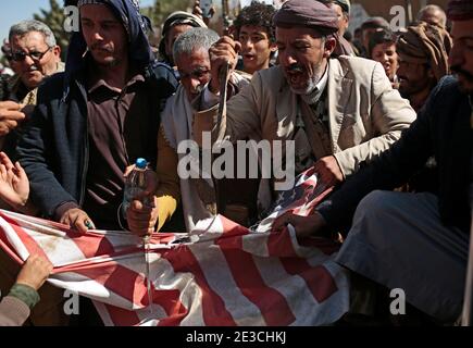 Sanaa, Yemen. 18 gennaio 2021. I sostenitori di Houthi stracciano una bandiera statunitense durante una protesta davanti all'ambasciata statunitense a Sanaa contro gli Stati Uniti per la decisione di designare il movimento dei ribelli Houthi come organizzazione terroristica straniera. Credit: Hani al-ANSI/dpa/Alamy Live News Foto Stock