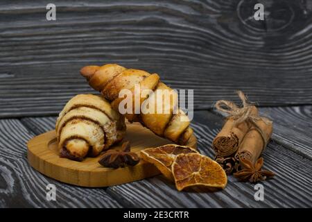 Cannella e ciambelle di semi di papavero. Pasticcini ricchi. Nelle vicinanze ci sono bastoncini di cannella, anice e arance secche. Primo piano. Foto Stock