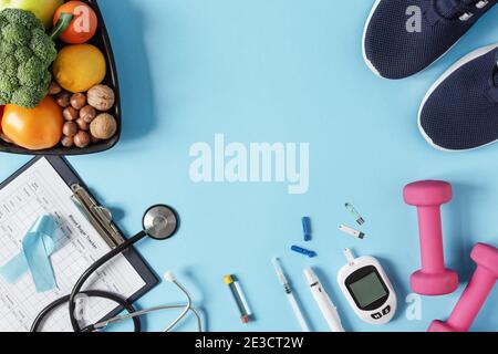 Mangiare sano e piano sportivo per i pazienti diabetici vista dall'alto su sfondo blu. Background concetto diabete. Foto Stock