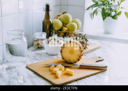 Kombucha fermentato ananas bere tepache. Processo di cottura della bevanda di ananas probiotica superfood fatta in casa. Bevi il vasetto e l'ananas a fette a casa Foto Stock