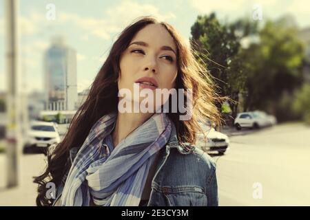 Ritratto di una bella bruna dai capelli lunghi in jeans con a. sciarpa Foto Stock