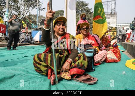 Kolkata, India. 18 gennaio 2021. Le donne anziane di diverse organizzazioni femminili hanno bandiere mentre si siedono sul terreno durante la protesta. Diverse organizzazioni femminili come l'AIDWA (All India Democratic Women's Association), l'AIPWA (All India Progressive Women's Association) e l'AIKSCC (All India Kissan Sangharsh Coordination Committee) hanno organizzato proteste e hanno marciato in tutto il paese prima del giorno della Repubblica di quest'anno, Esprimere solidarietà con la protesta degli agricoltori contro il governo indiano ha imposto nuove leggi agricole al confine con il Singhu, Delhi. Credit: SOPA Images Limited/Alamy Live News Foto Stock