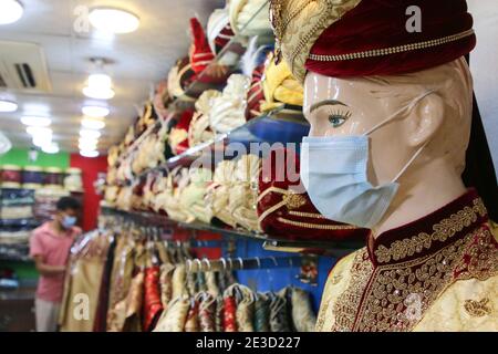 Dhaka, Bangladesh. 18 gennaio 2021. Un manichino dello sposo della sposa visto esposto con una maschera facciale ad un centro commerciale durante la pandemia del coronavirus a Dhaka.molti matrimoni sono stati rinviati a causa della pandemia del coronavirus. Dato che la situazione pandemica in Bangladesh sta migliorando giorno per giorno, il programma sociale e culturale come le cerimonie di nozze viene riorganizzato in modo nuovo e normale. Credit: SOPA Images Limited/Alamy Live News Foto Stock