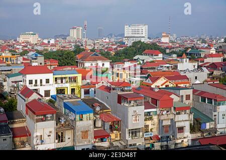 Vista aerea su case colorate e appartamenti della città Ninh Binh nel delta del fiume Rosso del Vietnam settentrionale Foto Stock