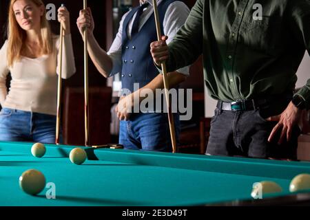 le persone che si levano in piedi, giocando a biliardo, snooker o in piscina insieme, si divertono. divertimento, biliardo, svago, concetto di riposo Foto Stock