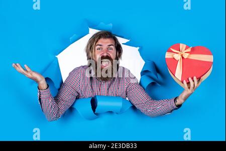 Vendite di San Valentino. Uomo maturo aperto in confezione regalo. Regalo per te. Uomo positivo che si diverte a fare shopping. Sorpresa per festeggiare l'anniversario. Buon giorno di San Valentino. Concetto di giornata dei padri. Risparmio sugli acquisti. Foto Stock