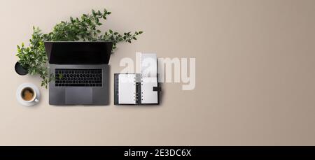 Scrivania da ufficio con vista dall'alto e spazio di lavoro con computer portatile su sfondo grigio. Spazio di copia. Foto Stock