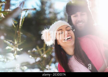 Divertente bella coppia sorridente nella foresta invernale Foto Stock
