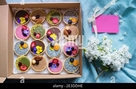 Selezione di dolci colorati e deliziosi in scatola sul tavolo, vista dall'alto. Foto Stock