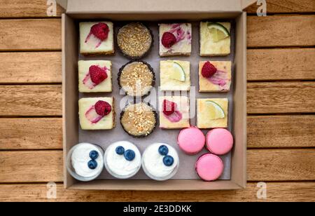 Selezione di dolci colorati e deliziosi in scatola sul tavolo, vista dall'alto. Foto Stock