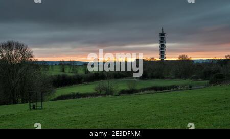 Il sole tramonta dietro la torre del trasmettitore Purdown BT a Stoke Park, Bristol. Foto Stock