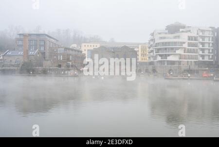 I cigni nuotano oltre i gas rigenerati mentre la nebbia sale dal porto galleggiante di Bristol. Foto Stock