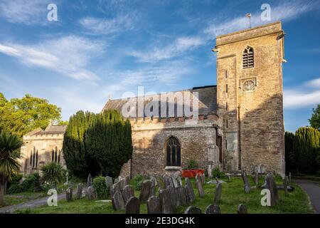 Il sole splende sulla tradizionale chiesa parrocchiale gotica di Santa Maria e sul cimitero di Henbury, a nord di Bristol. Foto Stock