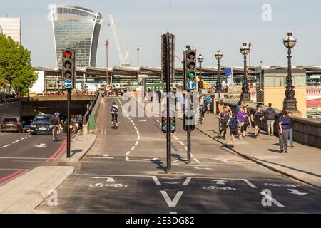 I ciclisti provano una sezione quasi completata della nuova Cycle SuperHighway 3 sull'Embankment di Londra, con piste ciclabili separate dal traffico di motori Foto Stock