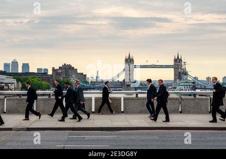 Londra, Inghilterra - 24 giugno 2015: Pendolari che attraversano il London Bridge per raggiungere gli uffici nel quartiere degli affari 'Square Mile' della City of London. Foto Stock