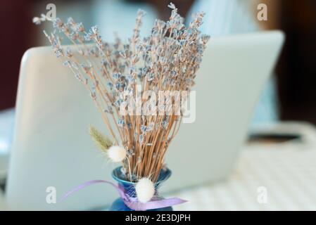 Primo piano foto di mazzo di fiori di lavanda secchi vicino alla scrivania in ufficio. Foto Stock