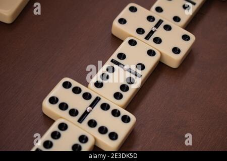 Dettaglio di dominoe corrispondenti o mattonelle domino su tavola di legno vista dall'alto. Primo piano del gioco. Giochi educativi, sviluppo e attività indoor Foto Stock