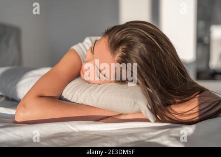 Dormite sul letto di cuscino di schiuma Asian girl che dorme sullo stomaco che riposa la testa sul cuscino di schiuma. Federa in seta per la cura dei capelli. Buona notte di sonno o a mezzogiorno Foto Stock