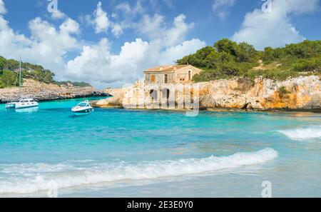 Paesaggio con vecchia casa e acque turchesi di mare a Cala Mondrago, isola di Maiorca, Spagna Foto Stock