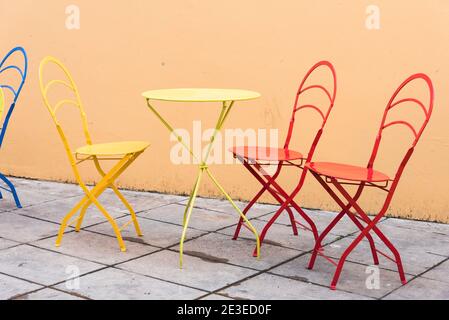 Set colorato di tavolo con sedie su una terrazza, mobili da esterno originali. Immagine con spazio di copia. Foto Stock