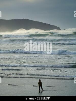 Una persona cammina sulla spiaggia durante il surf e le onde alte. Dillon Beach, California. Foto Stock