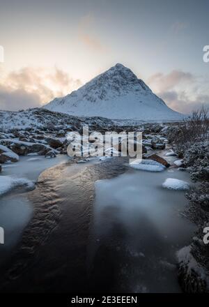 Il fiume Frozen Coupall attraversa Stob Dearg (il picco più importante di Buachaille Etive More) in una giornata invernale a Glencoe, Scozia, Regno Unito. Foto Stock