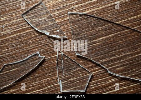 alcuni pezzi di vetro rotto su un vecchio tavolo di legno Foto Stock