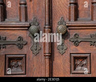 Vecchie porte esterne in legno con pannelli decorativi, pomelli in ottone e dettagli. Foto Stock