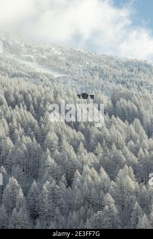 Un paesaggio invernale con solitaria capanna tra una foresta ghiacciata in Svizzera. Foto Stock