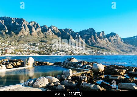 Paesaggio scenico e sereno delle piscine naturali blu scuro di marea di Maiden's Cove vicino a Camps Bay in Sud Africa Foto Stock