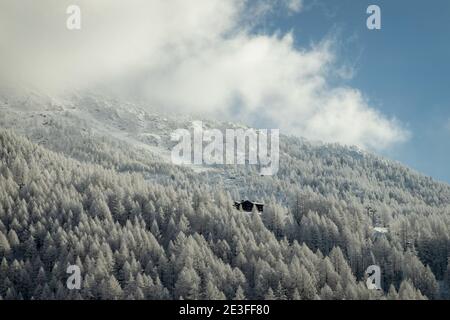 Un paesaggio invernale con solitaria capanna tra una foresta ghiacciata in Svizzera. Foto Stock