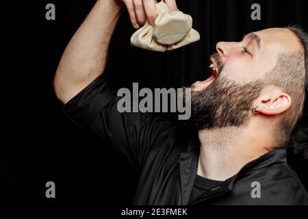 L'uomo bearded sta mangiando emotivamente khinkali. Il khinkali piatto georgiano nazionale. Concetto di pubblicità foto di khinkali Foto Stock