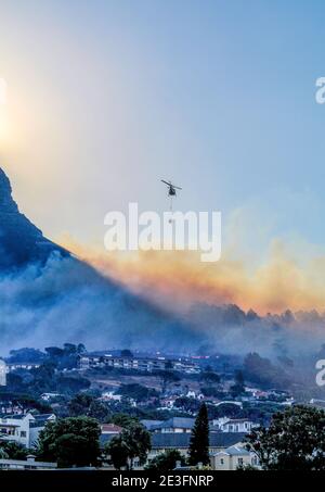 Elicotteri da caccia al fuoco che mettono in campo un infuriante fuoco selvatico sulla montagna Lion's Head a Città del Capo, Sud Africa Foto Stock