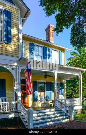 Un accogliente portico anteriore della vecchia casa vittoriana a due piani con sedie a dondolo e persiane a Fernandina Beach, FL, sulla storica Amelia Island Foto Stock