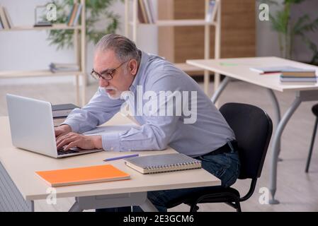 Vecchio insegnante di sesso maschile in classe scolastica Foto Stock