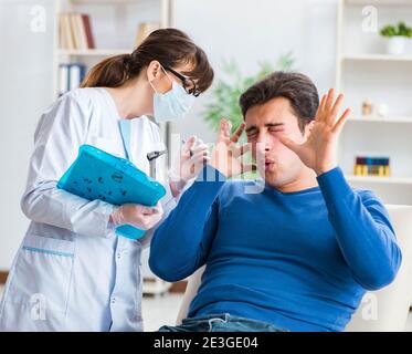 Il medico di controllo pazienti orecchio durante esame medico Foto Stock