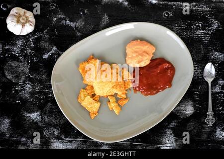 Nachos di mais messicani con salsa e salsa al formaggio tortilla chips con salsa piccante su tavola di legno scuro Foto Stock