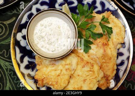 Piatto con merluzzo in pastella e salsa al ristorante Foto Stock