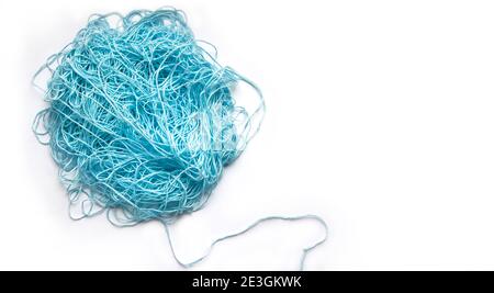 Il concetto di brainstorming. Un groviglio di menta, fili di cotone blu, filo di agugliatura. Banner su sfondo bianco con spazio per il testo. Foto Stock