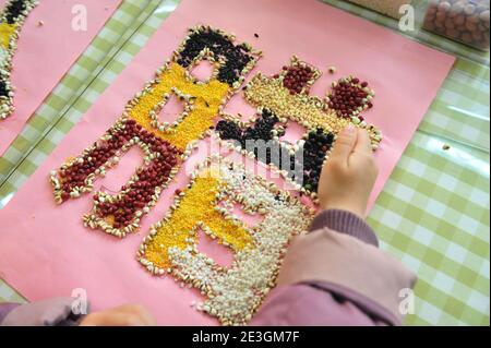 Xuzhou, Cina. 18 gennaio 2021. Per portare avanti la cultura tradizionale, un insegnante sta insegnando ai bambini la conoscenza dei grani al Laba Festival nell'asilo nido di Xuzhou, Jiangsu, Cina il 18 gennaio 2021.(Foto di TPG/cnsphotos) Credit: TopPhoto/Alamy Live News Foto Stock