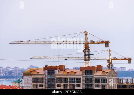 Costruzione gru torre sul cantiere di casa appartamento. Foto Stock