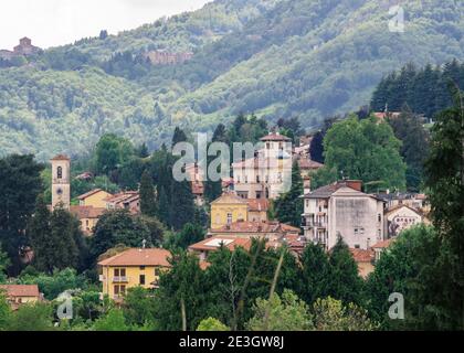 Veduta aerea di un paese con poche case sulle colline piemontesi immerso nel verde dei boschi. Biella, Italia. Foto Stock