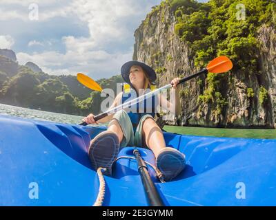 I viaggiatori di mamma, papà e figlio che girano su un kayak nella Baia di ha Long. Vietnam. Viaggio in Asia, emozione di felicità, concetto di vacanza estiva. Viaggiare con Foto Stock