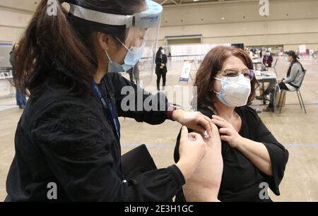 (210119) -- TORONTO, 19 gennaio 2021 (Xinhua) -- UNA donna che indossa una maschera facciale riceve una dose di vaccino COVID-19 presso una clinica di immunizzazione COVID-19 presso il Metro Toronto Convention Centre (MTCC) di Toronto, Canada, il 18 gennaio 2021. La prima clinica di immunizzazione COVID-19 di prova dell'Ontario ha aperto qui lunedì per contribuire a sviluppare un modello su come gli shot potrebbero essere somministrati in ambienti non medici. (Foto della Città di Toronto/Xinhua) Foto Stock