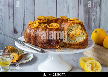 Torta di semi di limone e papavero con fette di frutta candite e glassa di limone Foto Stock