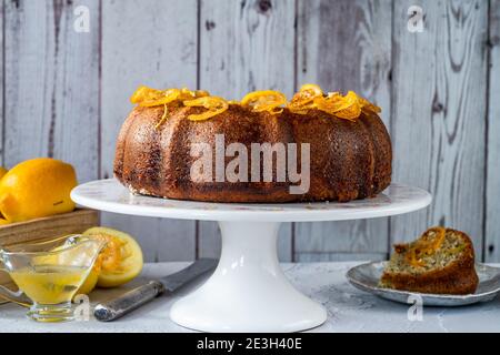 Torta di semi di limone e papavero con fette di frutta candite e glassa di limone Foto Stock