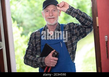 Ritratto di riparatore in piedi all'ingresso di una casa Foto Stock