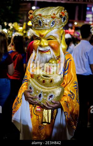 Un partecipante che indossa una maschera e un costume tradizionali cinesi in una sfilata durante il festival Lunar (o Cinese) di Capodanno a Yaowarat, Bangkok, Thailandia. Foto Stock
