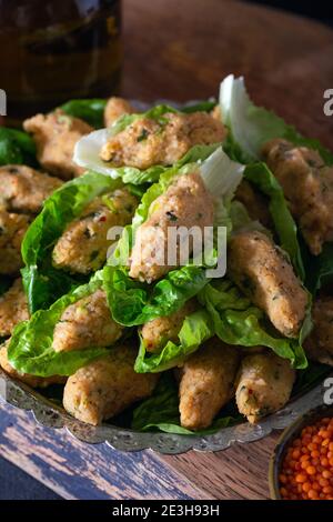 Palle di lenticchie cotte in stile turco. Cibo vegano turco Mercimek Koftesi (lenticchie). Piatti tradizionali locali con lenticchie e bulgaro. Foto Stock